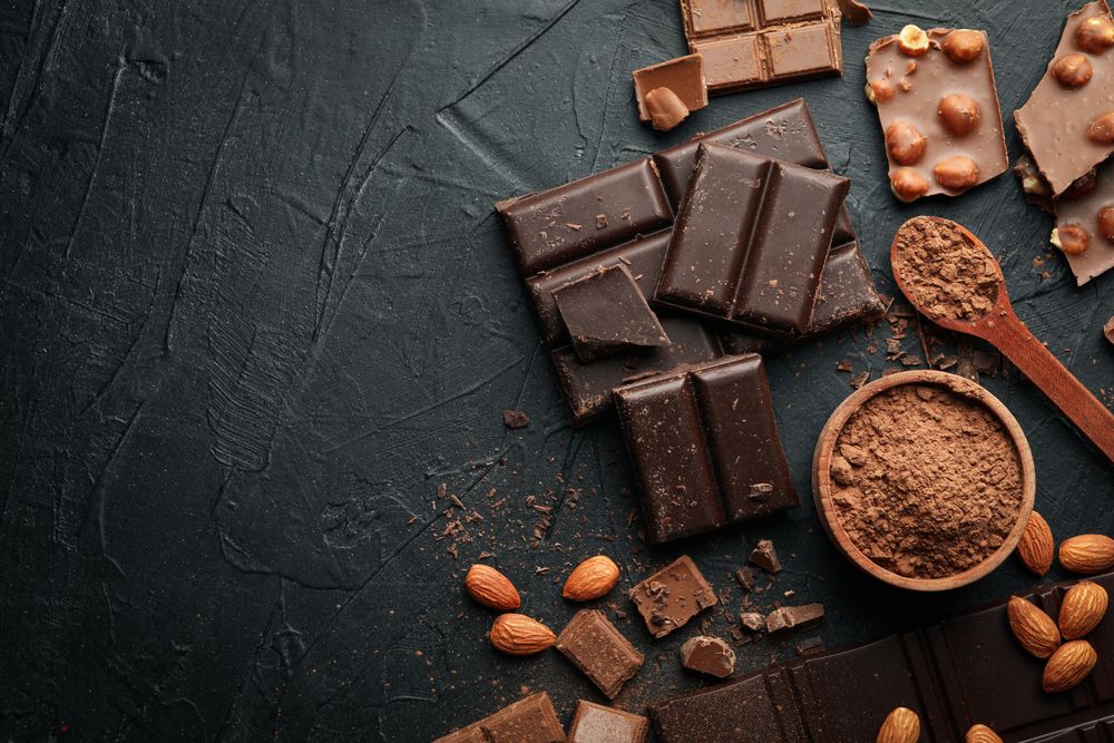 Chocolate, melted chocolate and almond on dark background
