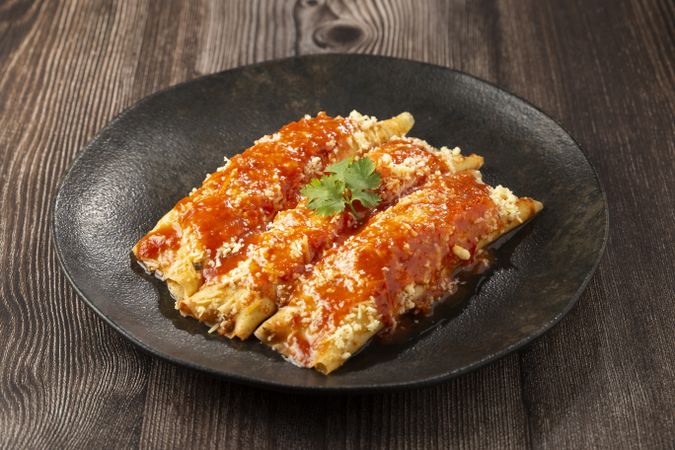 Pancakes stuffed with minced meat and topped with tomato sauce and grated cheese.
