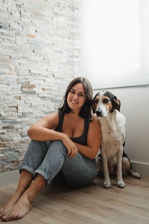 Woman with dog sitting on floor