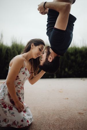 Tender couple kissing upside down on rural street