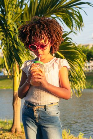 Hispanic Girl drinks juice from bottle