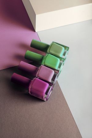 Multi-colored nail polish on pastel colors geometric pattern background