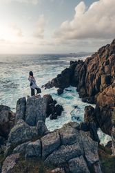 Woman looking at rocks at seaside