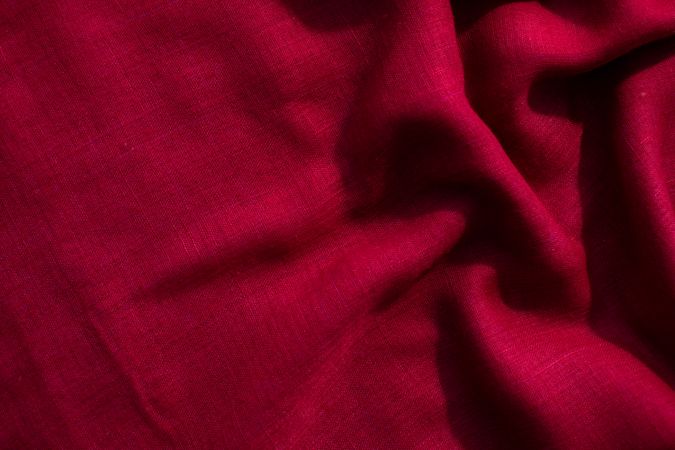 Red fabric wavy crumpled background texture with copy space.