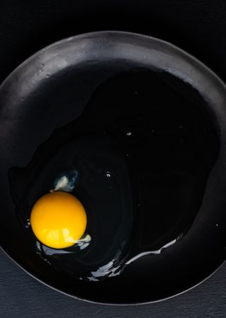Cracked raw egg on pan