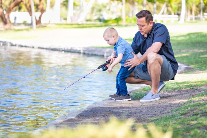 Young Father and Son Having Fun Fishing At The Lake