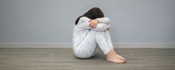 Woman crying with her head in her lap