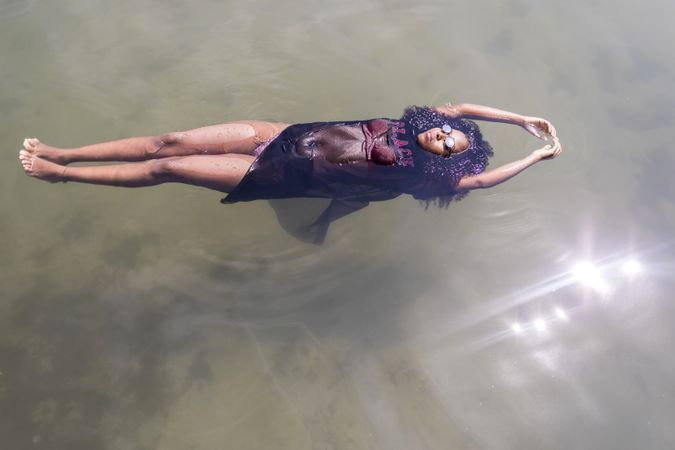 Black woman floating in a pool of water