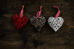 Valentine's day concept of three thatched heart decorations on wooden table
