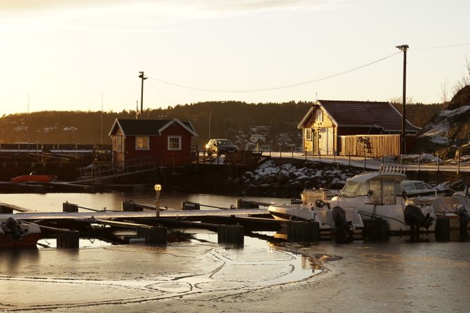 Coastal village next to pier with boat in frozen river