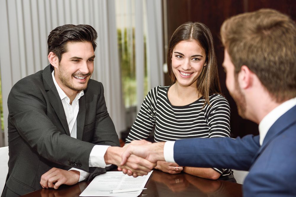 Two men shaking hands over a table in an office