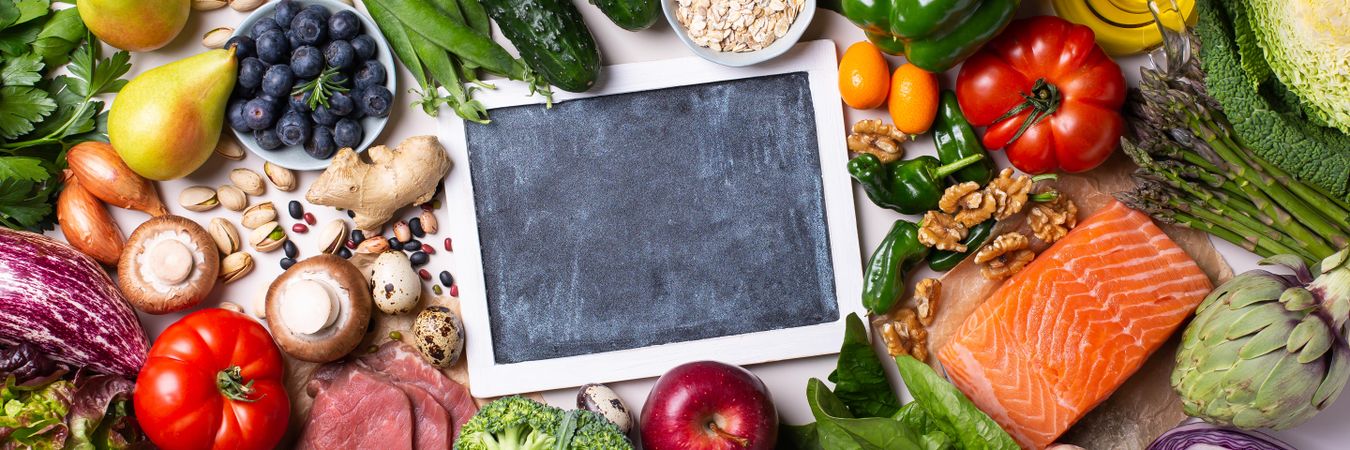 Banner of a healthy food mix fresh vegetables, fruit and fish with chalkboard in center