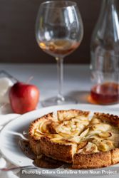Homemade apple tart on table with red apple and wine glass bxNOM5