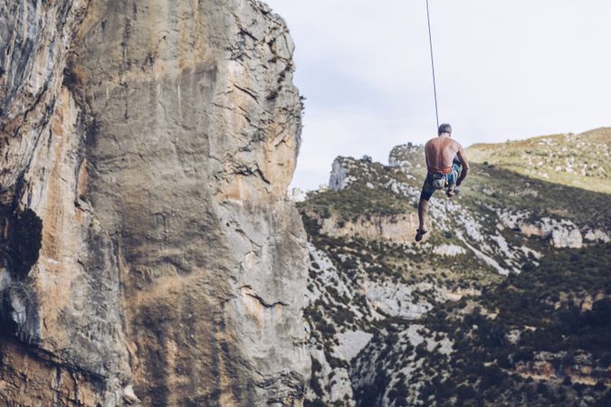 Anonymous climber handing on cliff