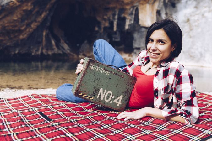 Cheerful woman with old case on picnic