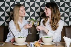 Cheerful friends clinking glasses in cafe