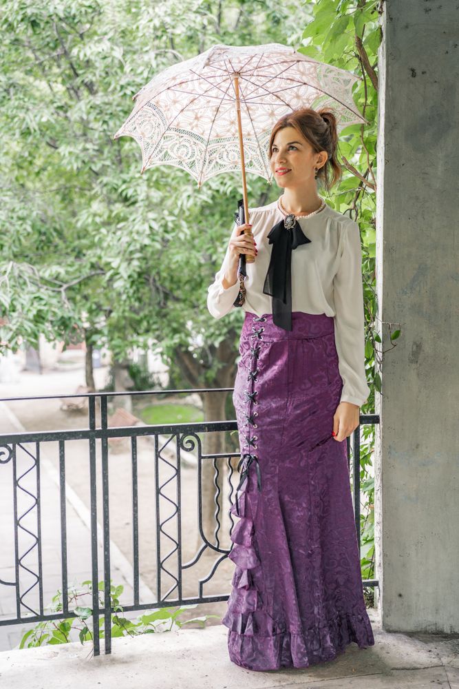 Vintage woman with parasol resting in garden