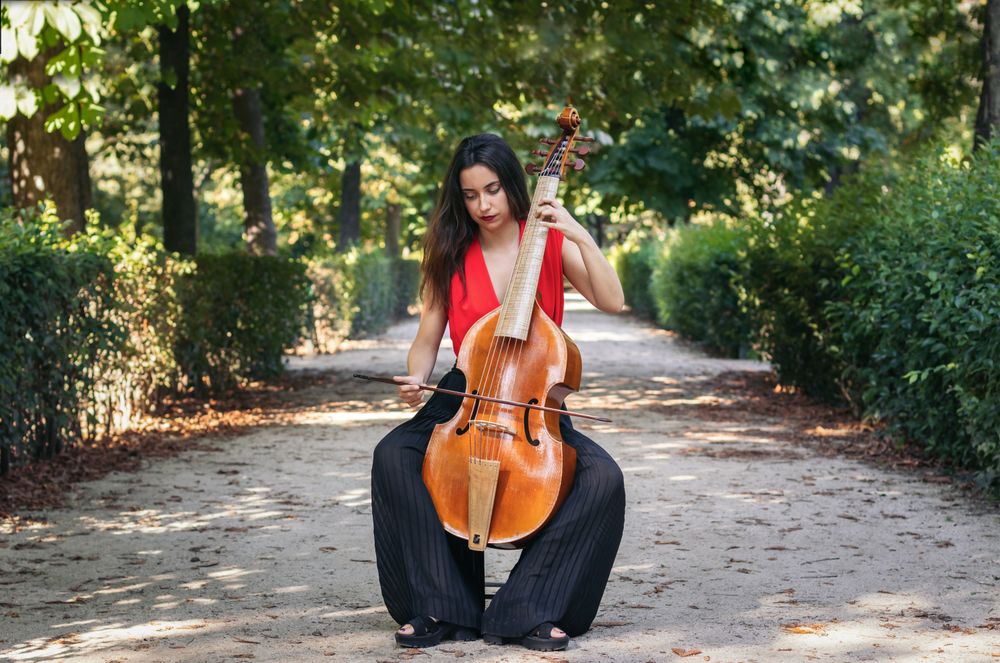 Woman playing the cello in a park.