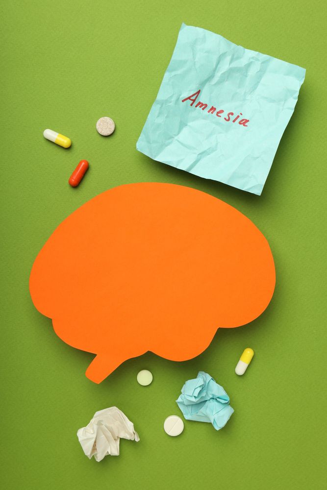Orange paper cut out of brain on green background, vertical