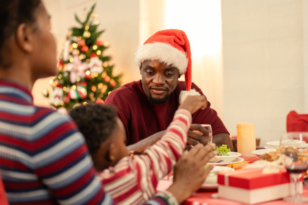 Black family celebrating Christmas dinner table