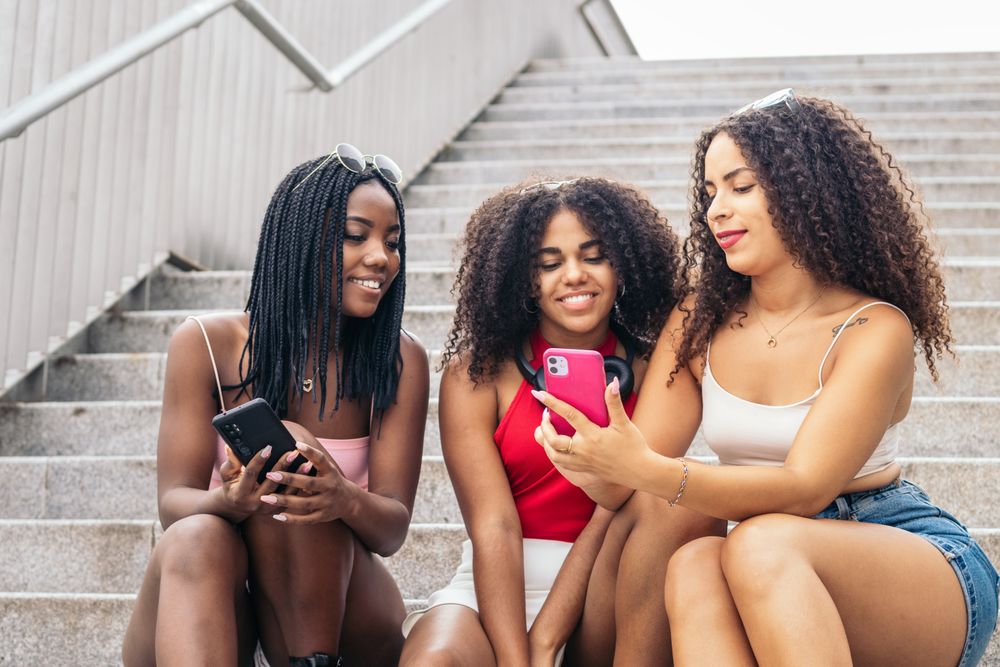 Black Friends Enjoying Summer Together and using smartphone