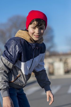 Teenager wearing a red hat boarding on the street