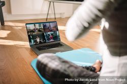 View of a woman conducting virtual fitness class with group of people at home on a video conference 41yl84