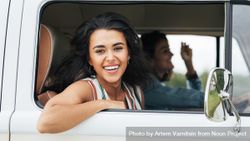 Beautiful woman smiling out from the passenger seat of a van 0gQ8e4