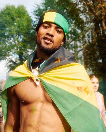 London, England, United Kingdom - August 27, 2022: Man dropped in Jamaican flag at street festival