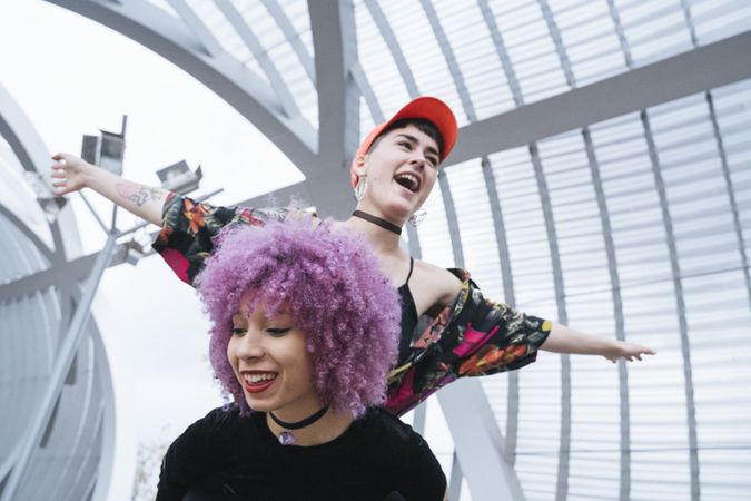 Woman holding girlfriend on back and laughing
