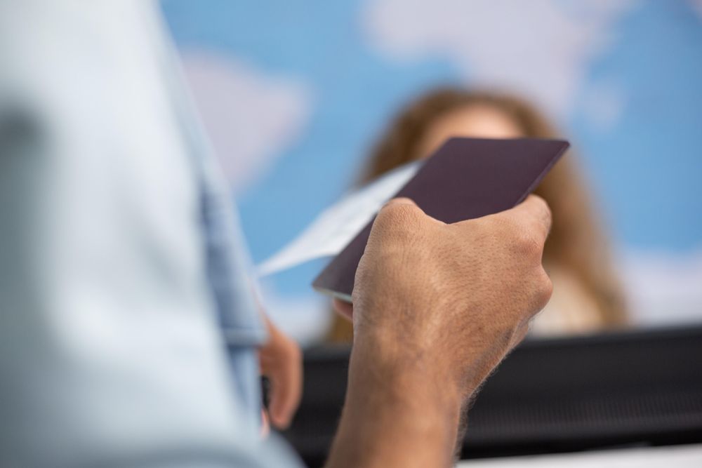 Close up of passenger holding passport in airport