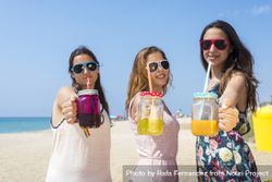 Group of happy teenage friends toasting non alcoholic drinks on summer beach 5oDZxx
