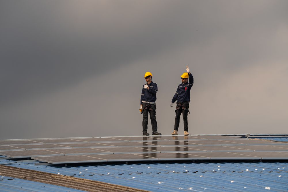 Engineer team checking solar cell  or photovoltaic cell installed on the roof of the factory. Technician worker repair or inspect the system. Industrial renewable energy concept
