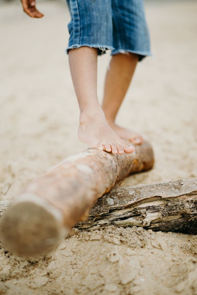 Anonymous Black kid walking on log