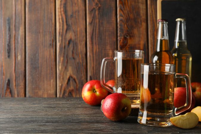 Composition with cider and apples on wooden background