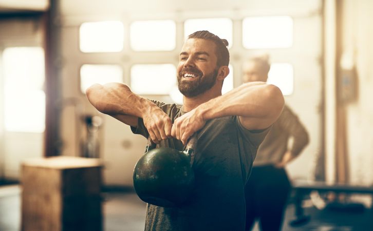 Man lifting kettlebell in gym
