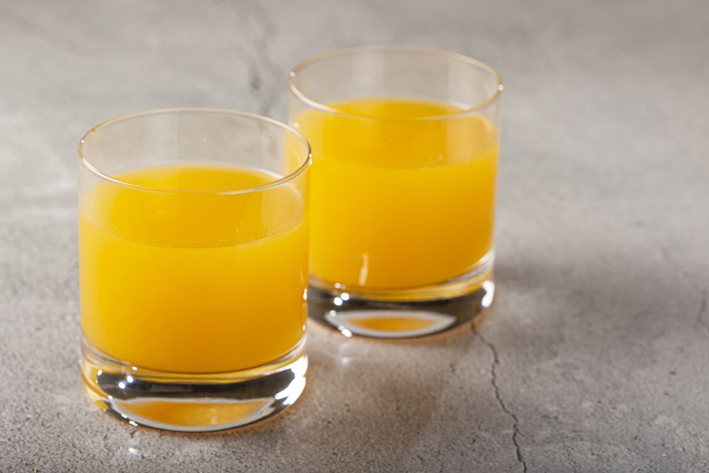 Glass with orange juice on the table.
