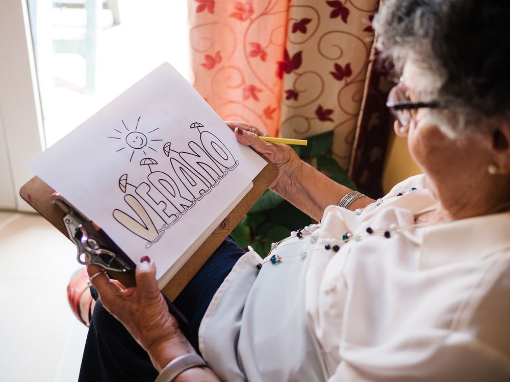 Mature female drawing on paper in apartment