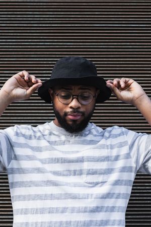 Black hipster man in hat looking down