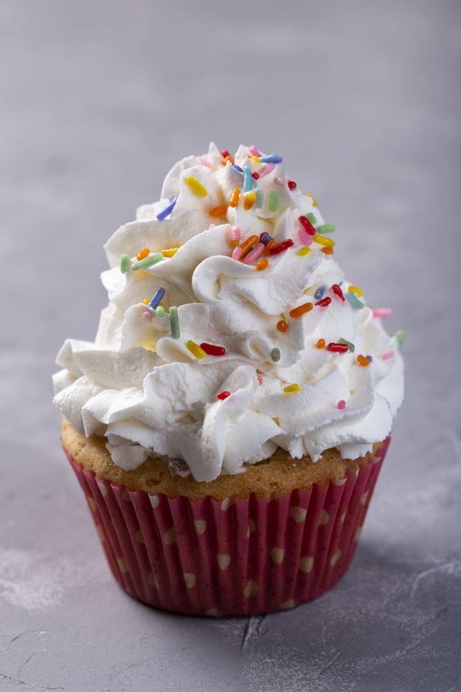 Tasty party cupcakes on the table. Cupcakes with whipped cream.