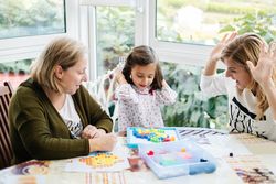 Woman playing board game with daughter and granddaughter