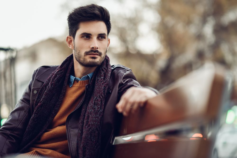 Thoughtful young man sitting on a bench