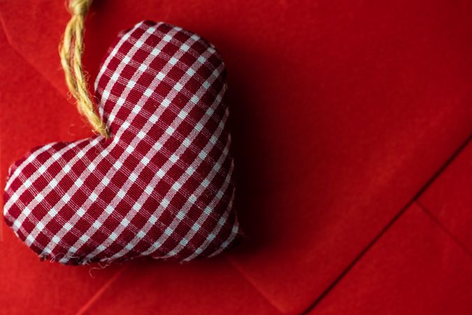 Checkered felt heart decoration on red envelope 