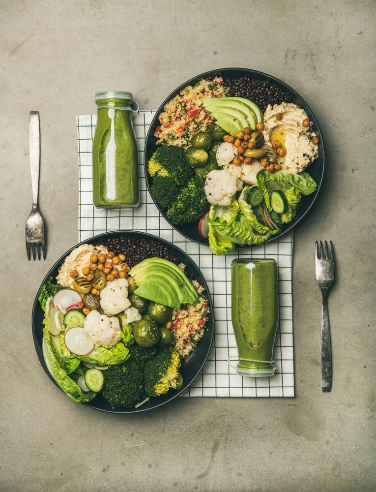 Two vegetarian bowls,  with smoothie, on placemat, vertical composition