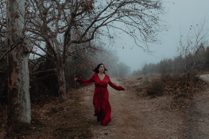 Woman in red dress walking in foggy area
