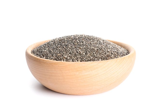 Chia seeds in wooden bowl isolated on studio background
