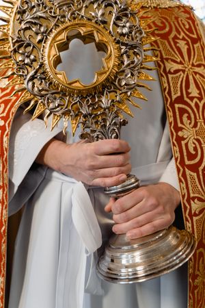 Christian priest holding the blessed Sacrament