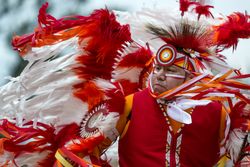 Red Wing, MN, USA - July 8th, 2017: Native American man in red traditional regalia and headdress