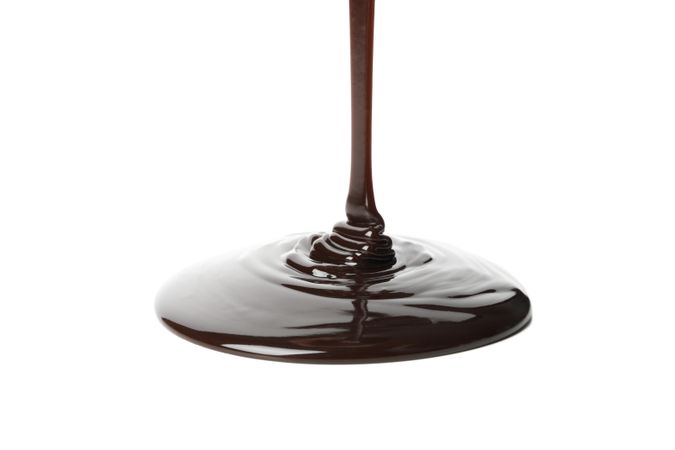 Melted chocolate is pouring, isolated on blank background