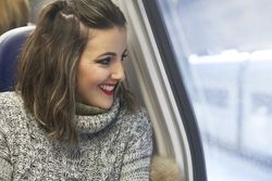 young woman looking through window in train